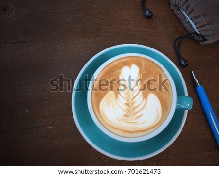 top view hot coffee in blue cup and pen on table background
