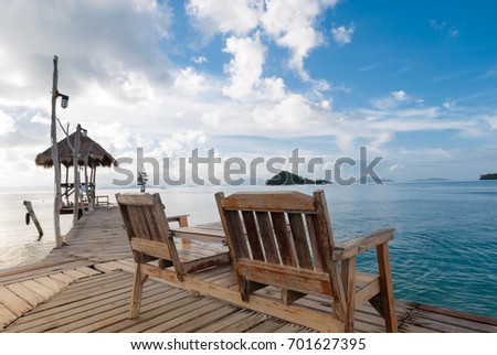 Natural lighting and shadow of blur wood bench on wooden bridge in sea of Koh mak,Trat,Thailand. wood bench on wooden bridge and blue sky background with copy space in seascape and traveling concept.