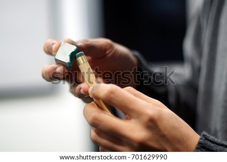 Billiard player rubs chalk his cue. Details of the game of billiards. Low light by intention Royalty-Free Stock Photo #701629990