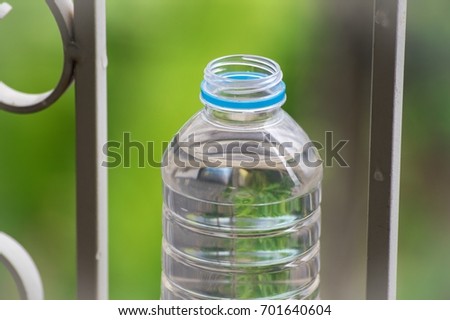 Bottle  water made to plastic on the wood and tree blurry bokeh background in garden. Using wallpaper for package or product and refreshing image.