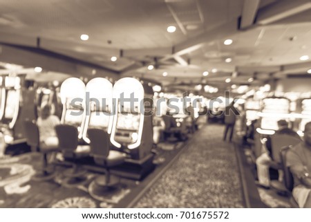 Blur slot machines, themed game, roulette slot poker 777, armed bandit with players at casino in Louisiana. Colorful illuminated light row digital machines. Gambling abstract background. Vintage tone