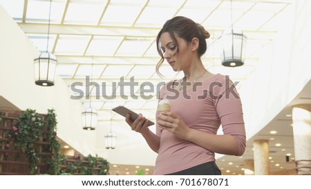 Attractive young woman doing selfie and eating ice cream at the Mall