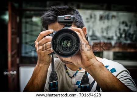 Close up portrait of photographer taking pictures with digital camera High Dynamic Range tone Royalty-Free Stock Photo #701694628