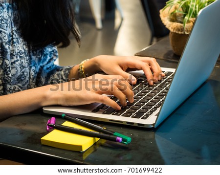 Hand close up, Side view. Young business woman sitting at table and typing on computer laptop. On table is laptop, Concept for freelance online blogger.