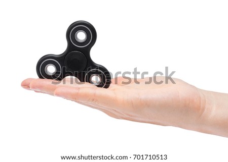 Hand holding Black Fidget Spinner isolated on white background.