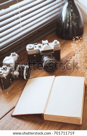 Vintage film camera and notebook and dry flower on wooden table. Top view .selective focus.