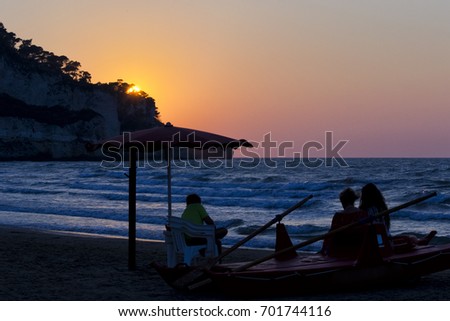 Family in silhouette watching sunset on a lifeguard boat. for vacation and summer holiday concept
