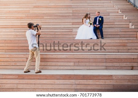 Videographer taking Pictures of the Bride and Groom at wooden steps