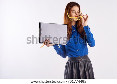 Woman in glasses holds documents, teacher.