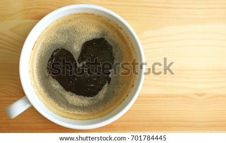 Heart shape hot black coffee foam, top view with free space on wooden table for text and design 