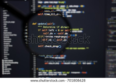 Real Python code developing screen. Programing workflow abstract algorithm concept. Lines of Python code visible under magnifying lens.