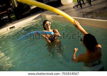 Young women having fun in the swimming pool at hot summer day