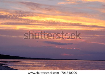 Colorful sunset on beach with clouds in the sky