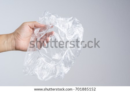 Hand holding disposable transparent plastic shower cap on white background Royalty-Free Stock Photo #701885152