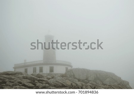 Over the rocks of Corrubedo the lighthouse emerges. This picture is from a foggy day of September, when the visibility was reduced. Still, the lighthouse can be seen over the rocks of the coast.