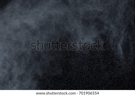 Freeze motion of white dust explosion on black background. Stopping the movement of white powder on dark background. Explosive powder white on black background