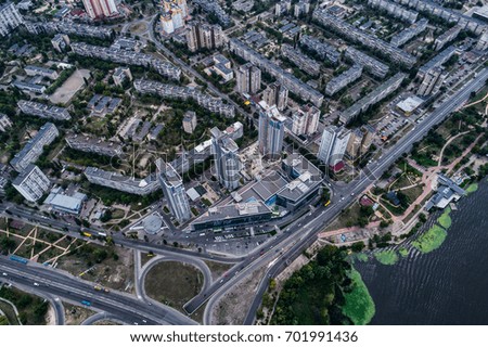 Residential district in a large metropolis with road junctions and houses. View of a newly built residential complex with a shopping center on the lower floors. Aerial view. From above