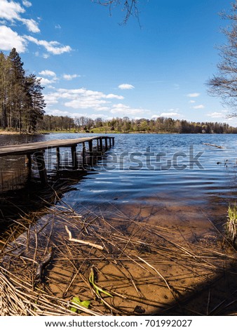 reflection of clouds in the lake with boardwalk and blue skies in background - vertical, mobile device ready image