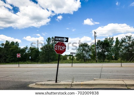 One way sign and Stop sign on the street 