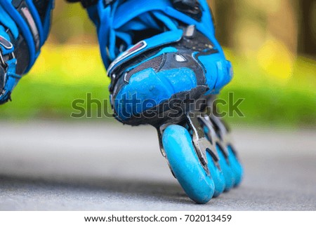 Close up of inline roller skate blue wheels.
