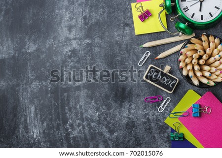 Education, back to school concept. Assortment of school stationery, supplies, pencil, pen, note on a grunge chalkboard. Copy space background, flat lay, top view