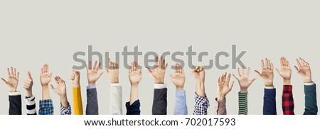 Many hands raised together Royalty-Free Stock Photo #702017593