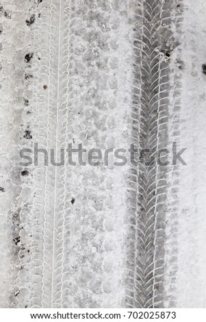 traces of the car's tread on the snow. Winter. A close-up photograph in cloudy weather