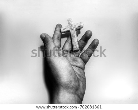 Hand holding christian cross, monochrome process