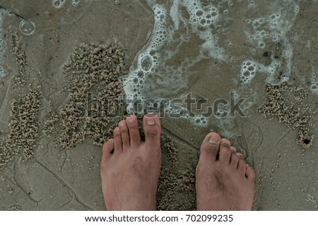 Asian Men feet on sand with Bubbles On Beach. Top view