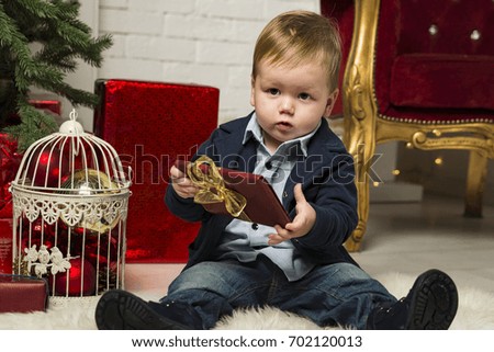 the little boy holds a Christmas gift in hand, close-up