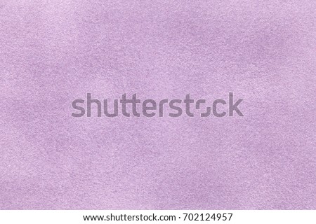 Background of light violet suede fabric closeup. Velvet matt texture of lilac nubuck textile.