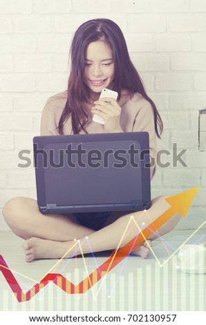 Beautiful young asian woman using laptop on wall background.