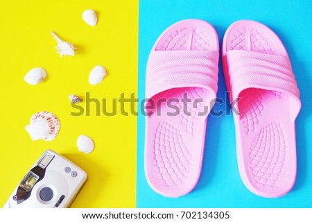 Beach flat lay photo. Retro camera, seashells and pink slippers on a yellow and blue background. Top view stock photography. Travel concept. Sea trip