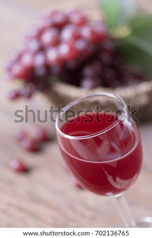 Close up of Glass of wine or grape juice and fruit on wooden table .
