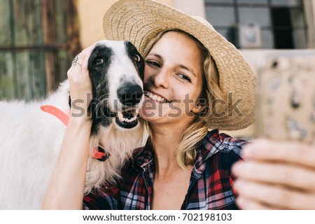 Young woman taking self portrait wit her dog for social media profile picture