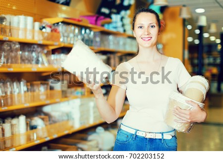 Smiling woman choosing objects for kitchen at accessories shop