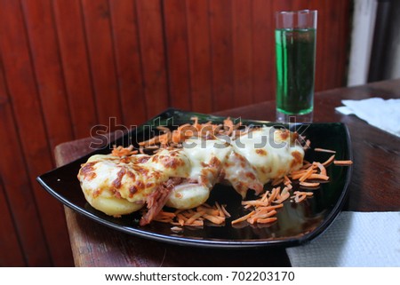An appetizer called Potato slipper with potatoes baked with yellow cheese, decorated with carrots and cabbage