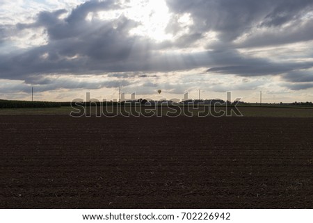 on a very sunny day in august in south germany you see road  beside green fields with contrastful cloudy sky