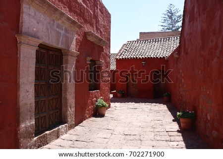 Santa Catalina monastery in Arequipa, a building full of color walls in white, red and blue with plants and vintage details from colonial times, during the morning on a sunny day, Peru