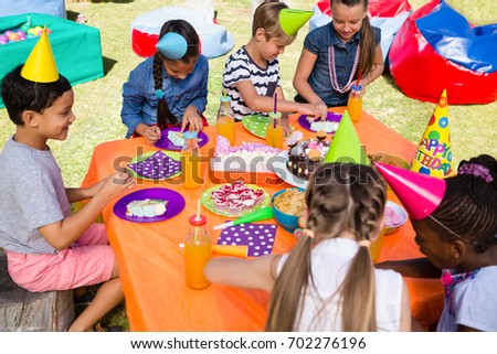 High angle view of children at table in yard during birthday party