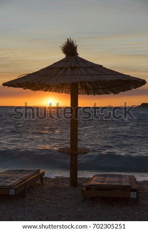 Parasol at Adriatic Sea in Primosten Croatia. Beautiful nature and landscape photo of nice warm summer evening at ocean. Calm, peaceful and joyful picture. Lovely sunset in evening.