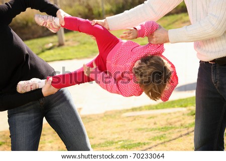 A picture of two adults fighting for an innocent child in the park