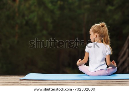Little girl doing fitness outdoor