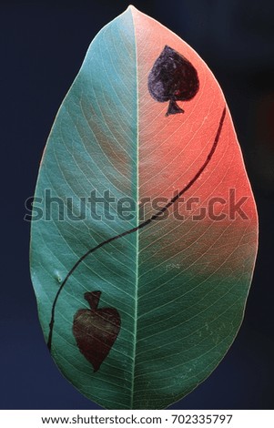 spade and heart painting on green leaf  on red light and black background
