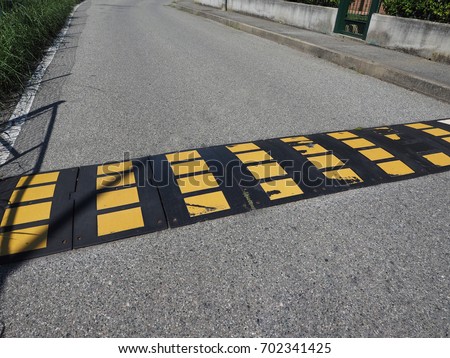 speed bump (aka as speed hump or sleeping policeman) to limit speed of cars traffic sign