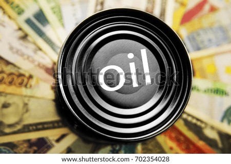 black oil drum set on dollar banknotes pile, Oil seeps from the tank, against the background of the money of different money bills. The concept of oil business, industry. Barrel