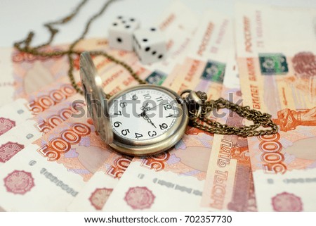 Money and clock on a chain on a white background. Time is money.