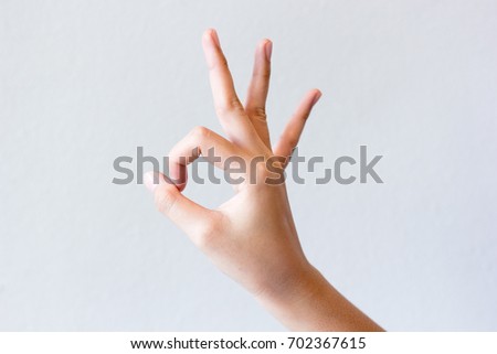 Woman hands isolated showing ok sign on grey background, gesture of "ok".