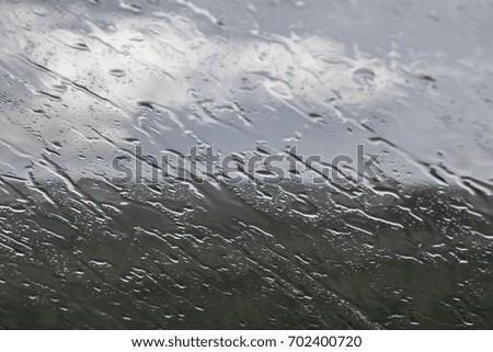 Sloping streams of water on glass with blurring background