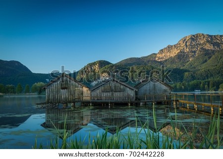 boatshouses on a lake Royalty-Free Stock Photo #702442228